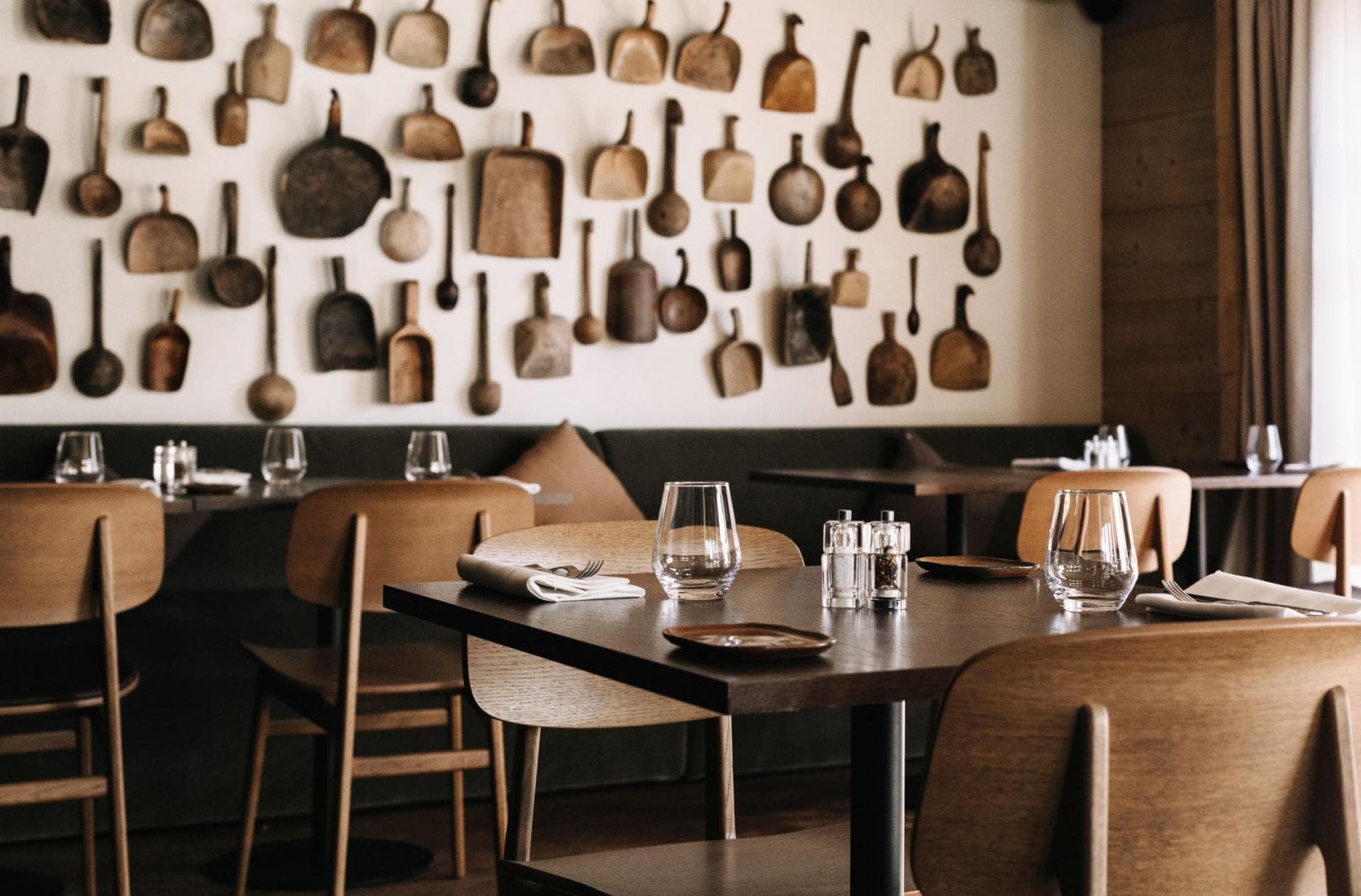 Dining area with banquette seating and vintage wooden utensil display