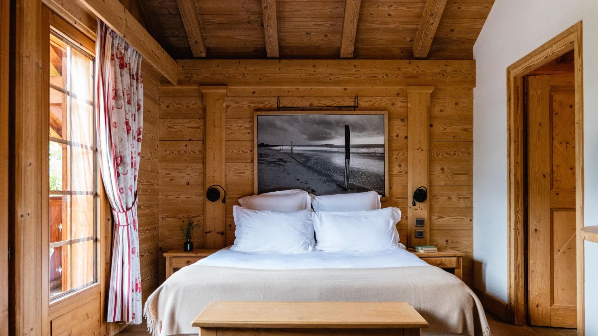 Wood-paneled bedroom with king bed and timber ceiling