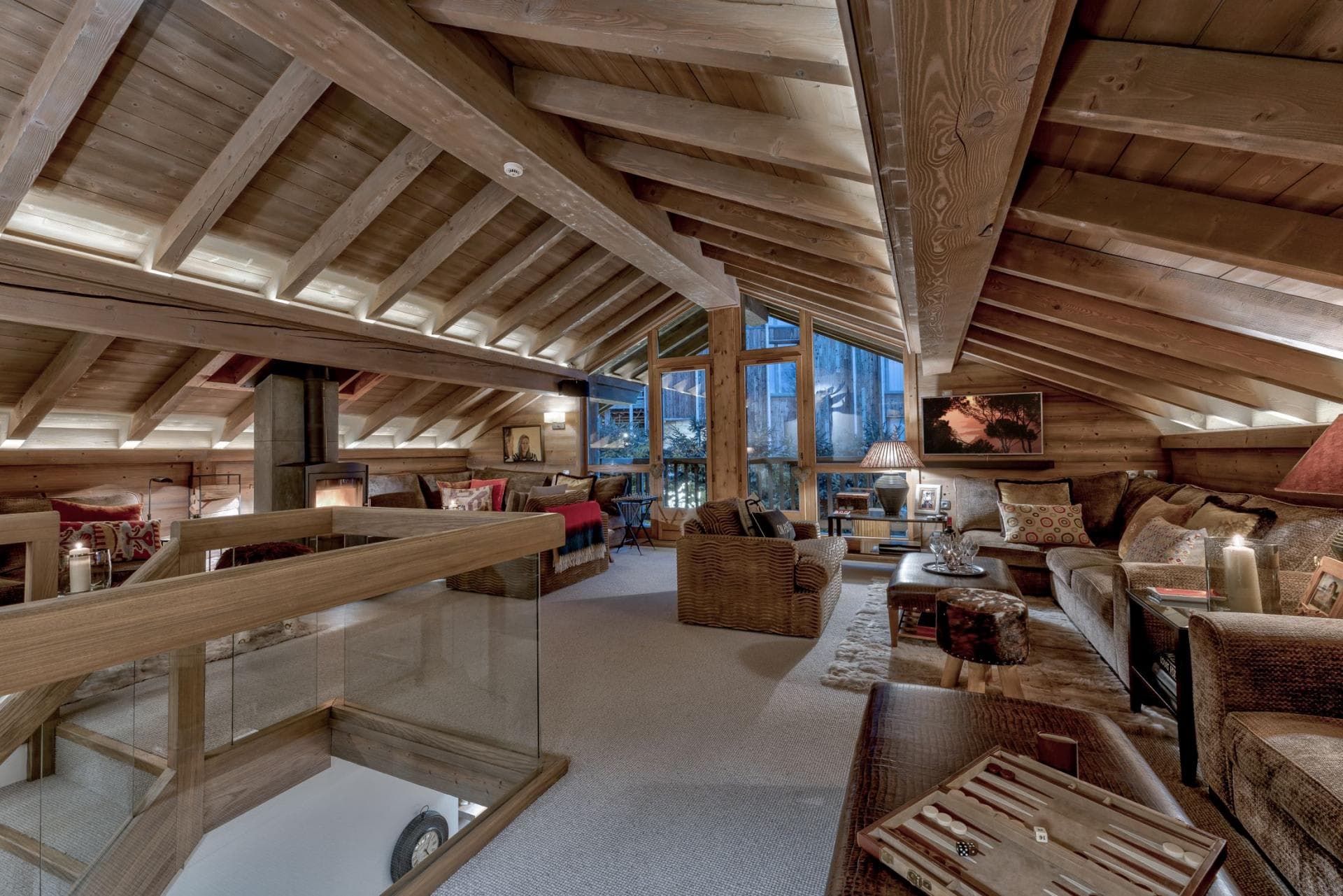 Loft living area with vaulted timber ceilings and wood-burning stove