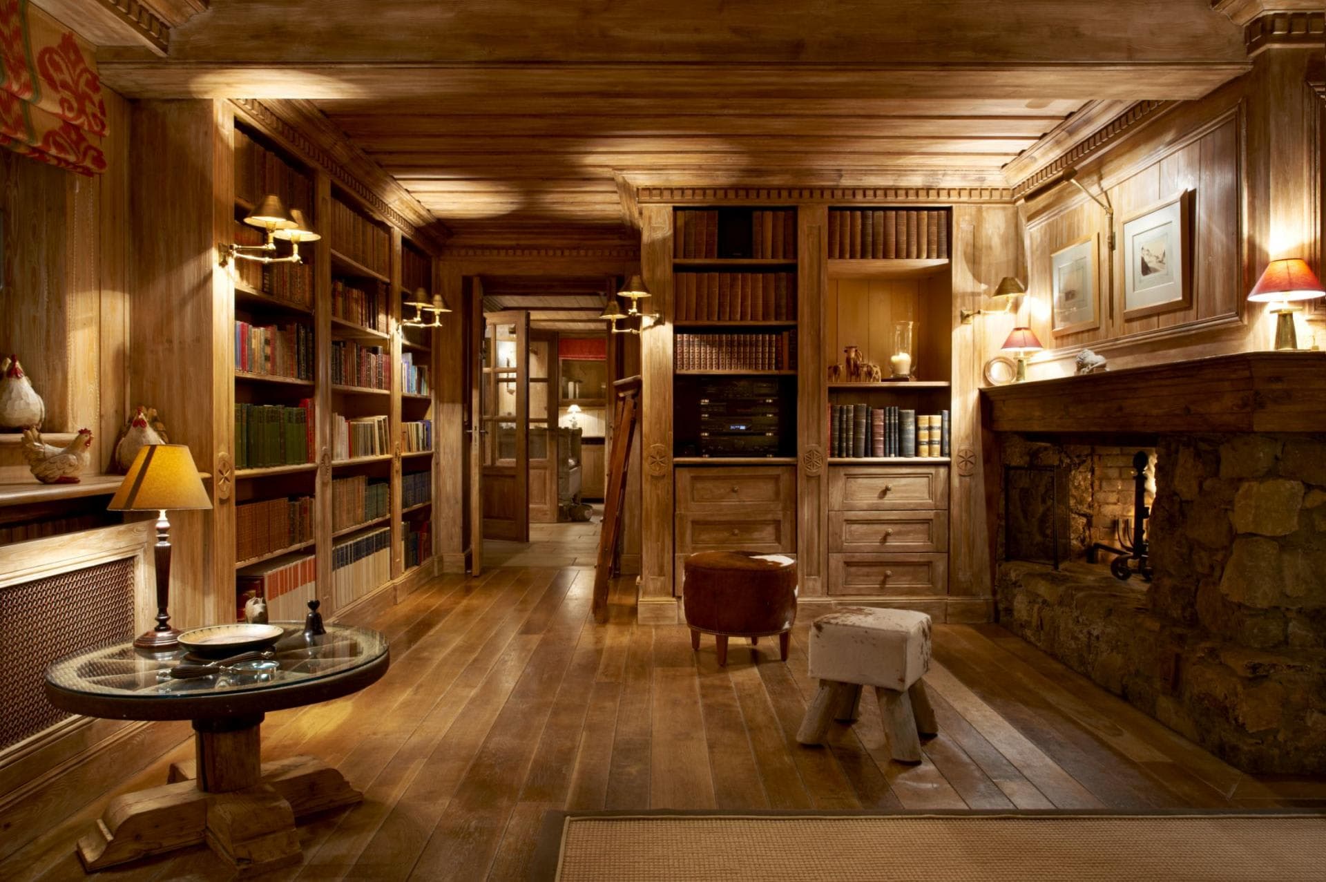 Wood-paneled library with wood-burning fireplace and built-in shelving