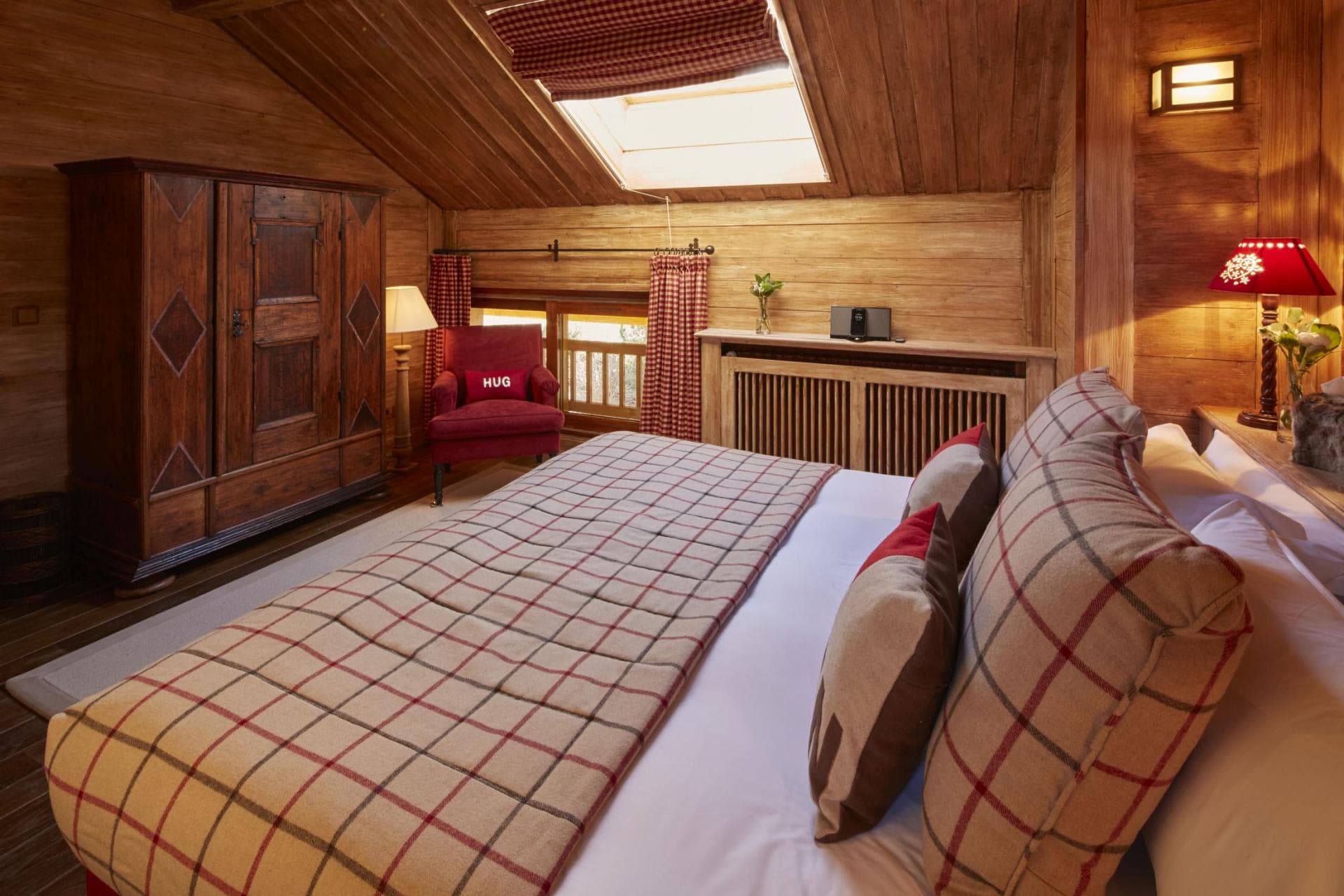 Attic bedroom with king bed, skylight, and timber-paneled walls