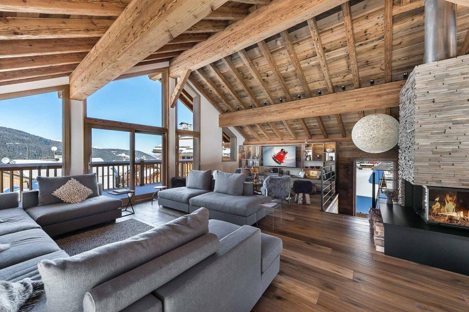 Living area with wood-burning fireplace and floor-to-ceiling mountain views