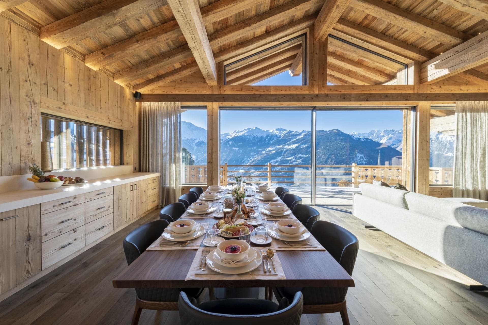 Dining area seats 12 with floor-to-ceiling mountain views and terrace access