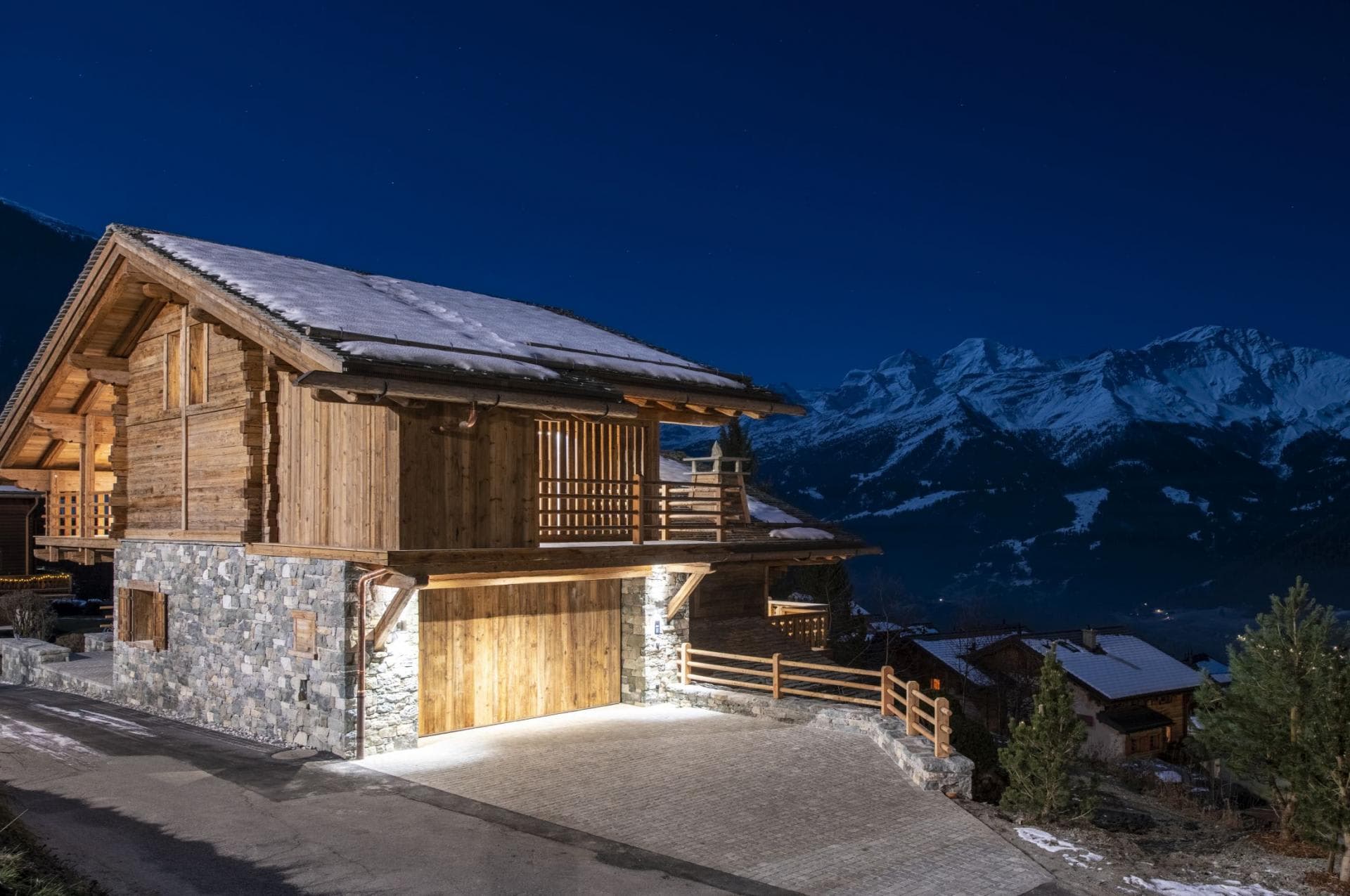 Chalet exterior at night with heated driveway and two-car garage