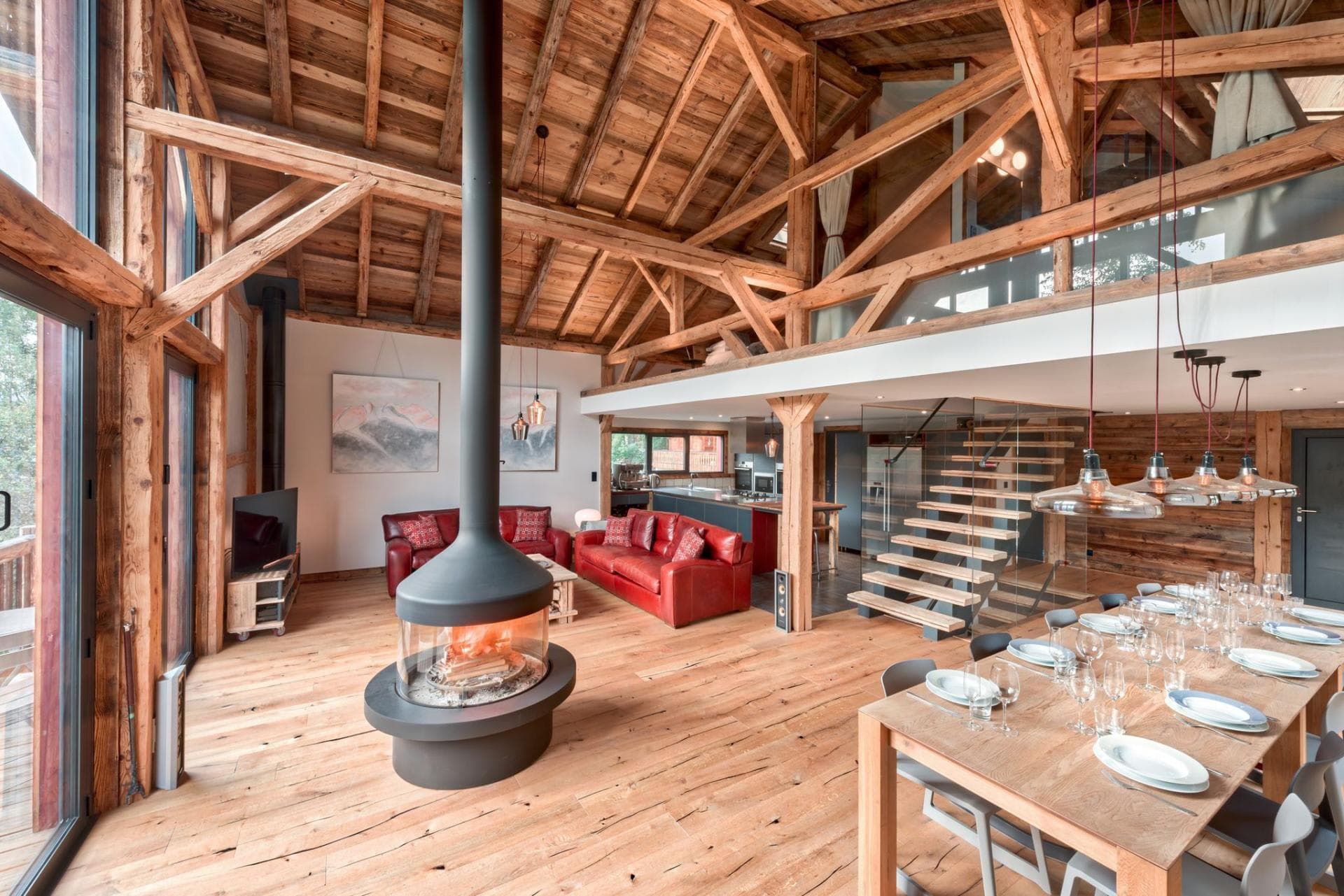 Open-plan living and dining area with exposed timber and a central wood-burning stove