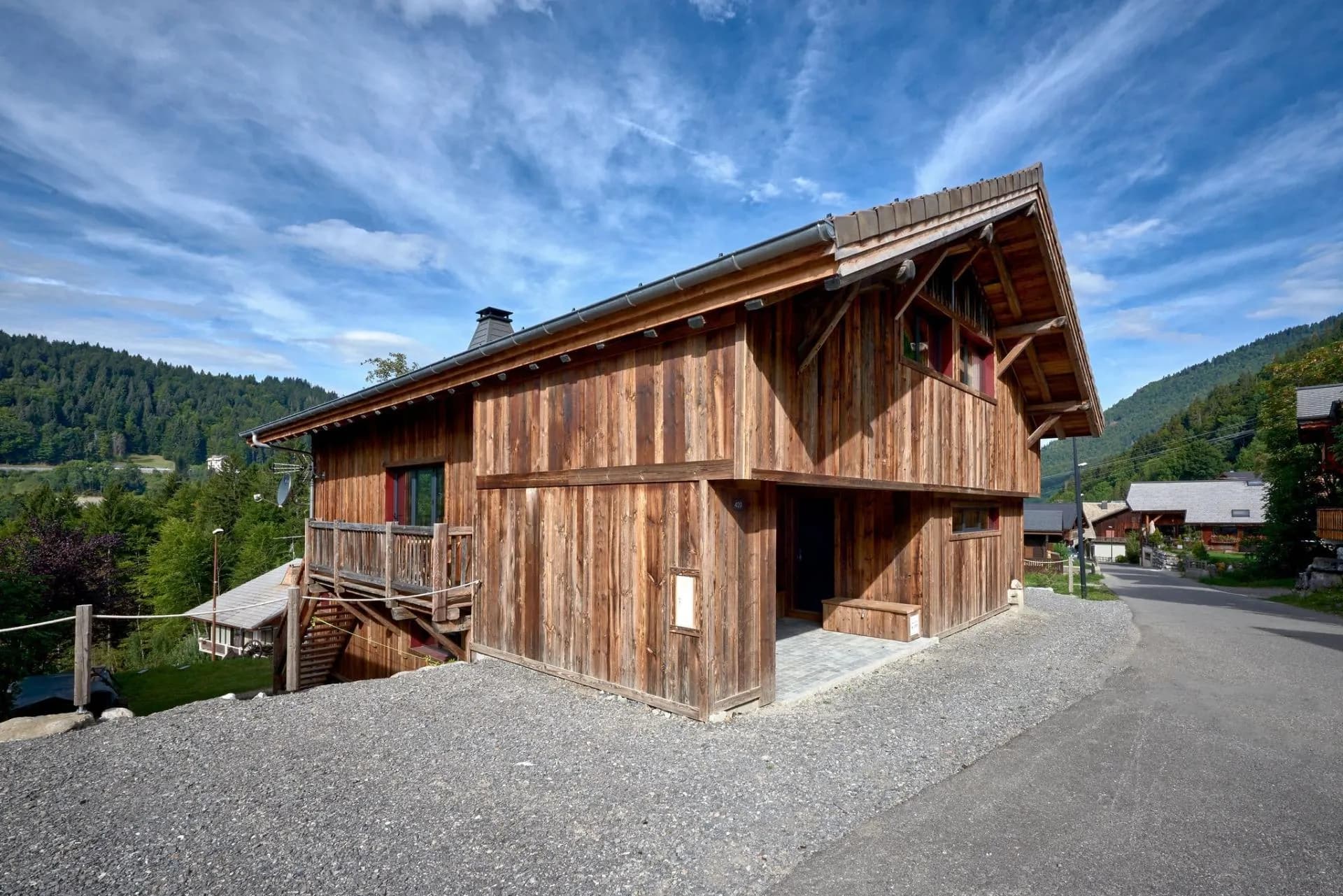 Timber-clad chalet exterior with a private balcony and garden