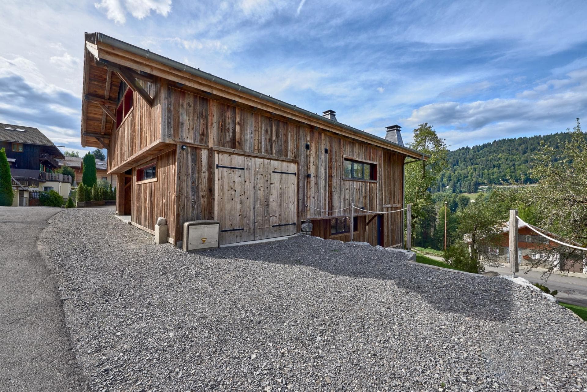 Timber-clad chalet exterior with private parking and gear storage