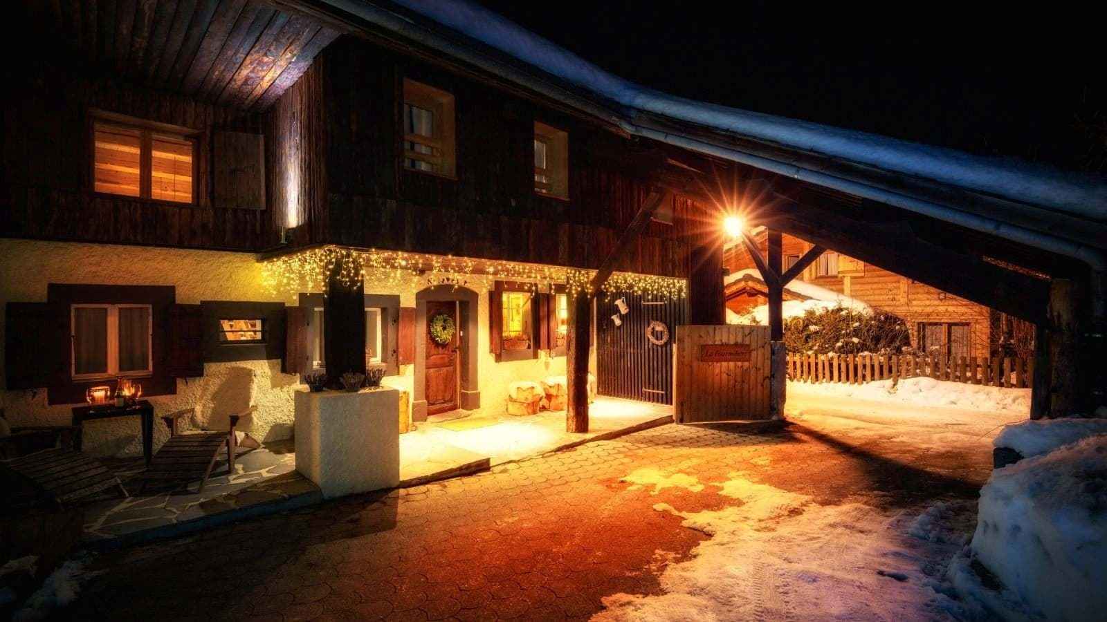 Chalet entrance with covered parking and festive lighting