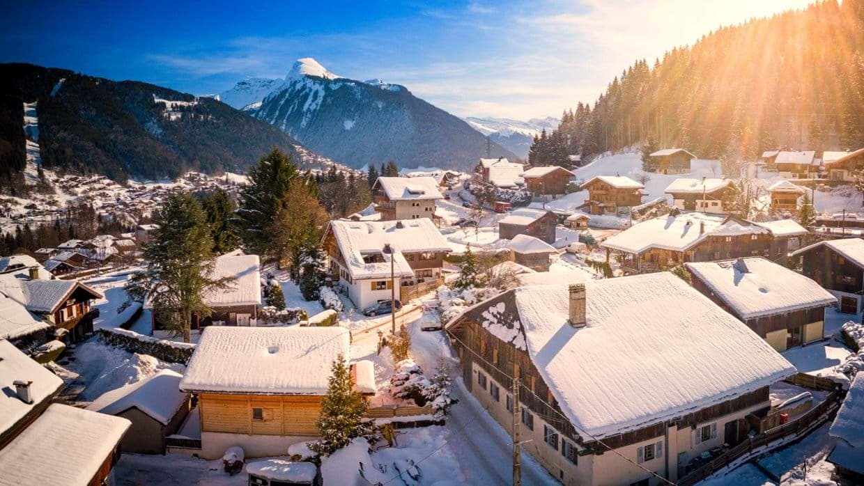 Panoramic alpine village views with snow-covered chalets and mountain peaks