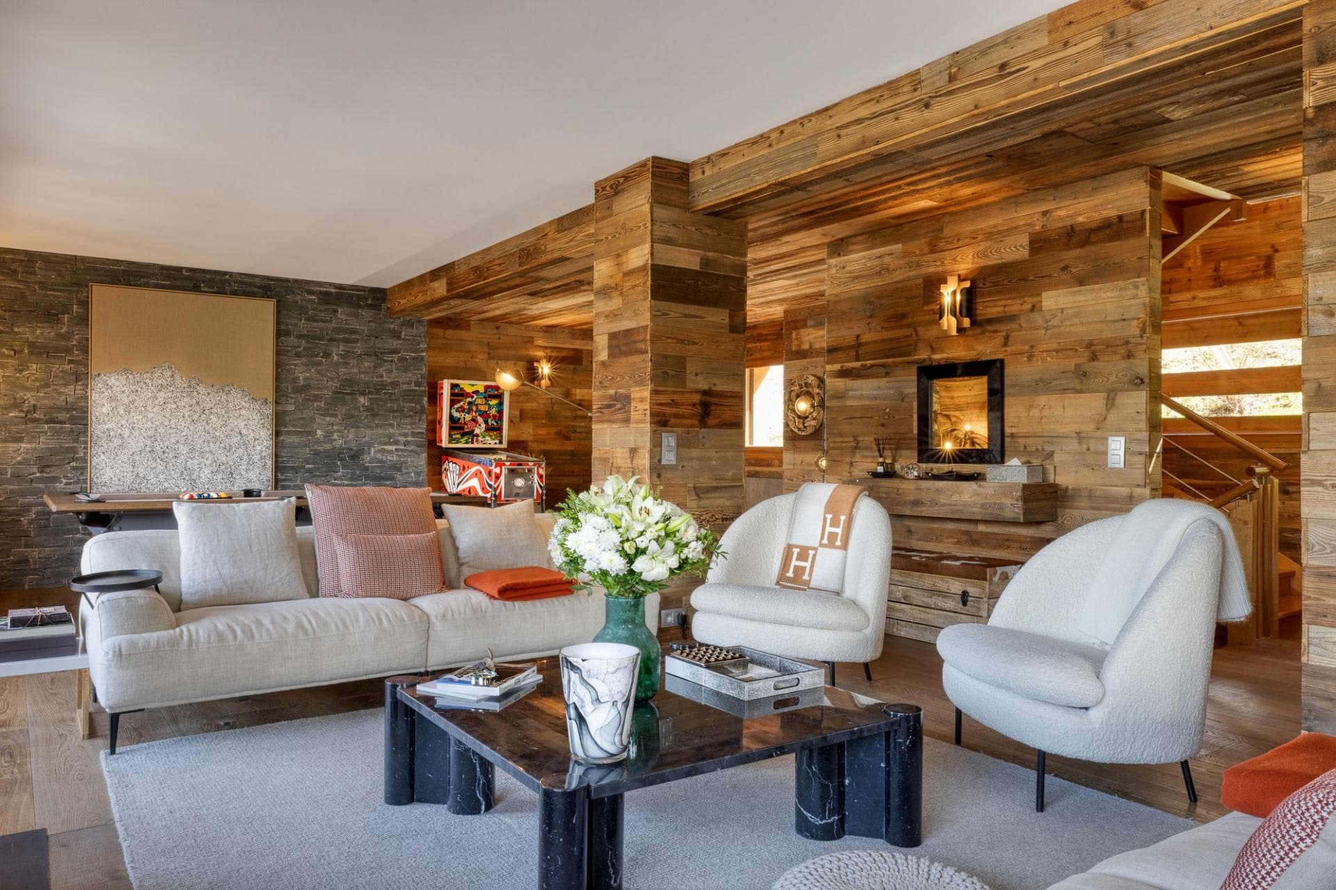 Living area with reclaimed wood walls, pinball machine, and pool table