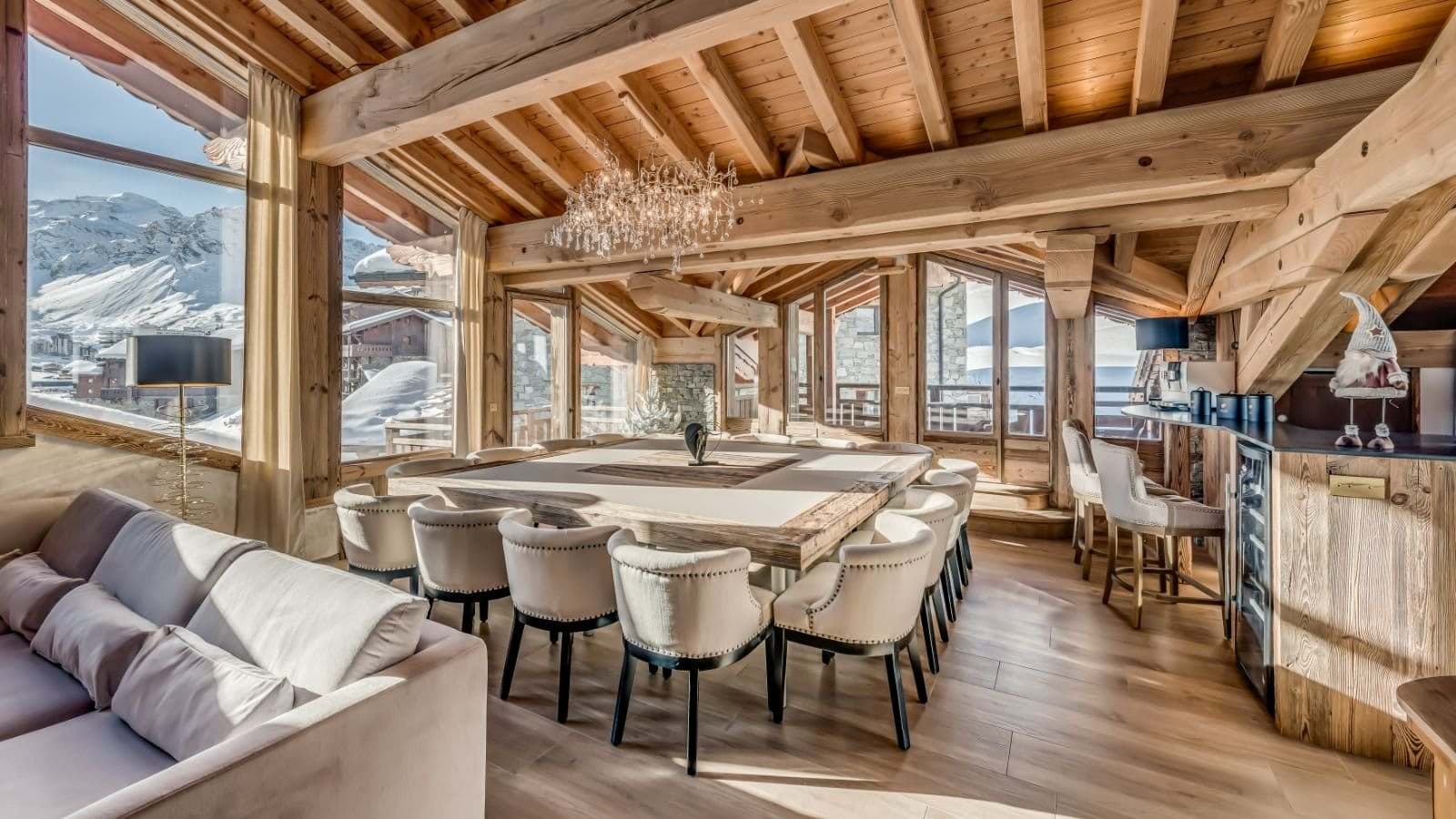 Open-plan dining and living area seats 8; crystal chandelier, exposed beams, alpine views