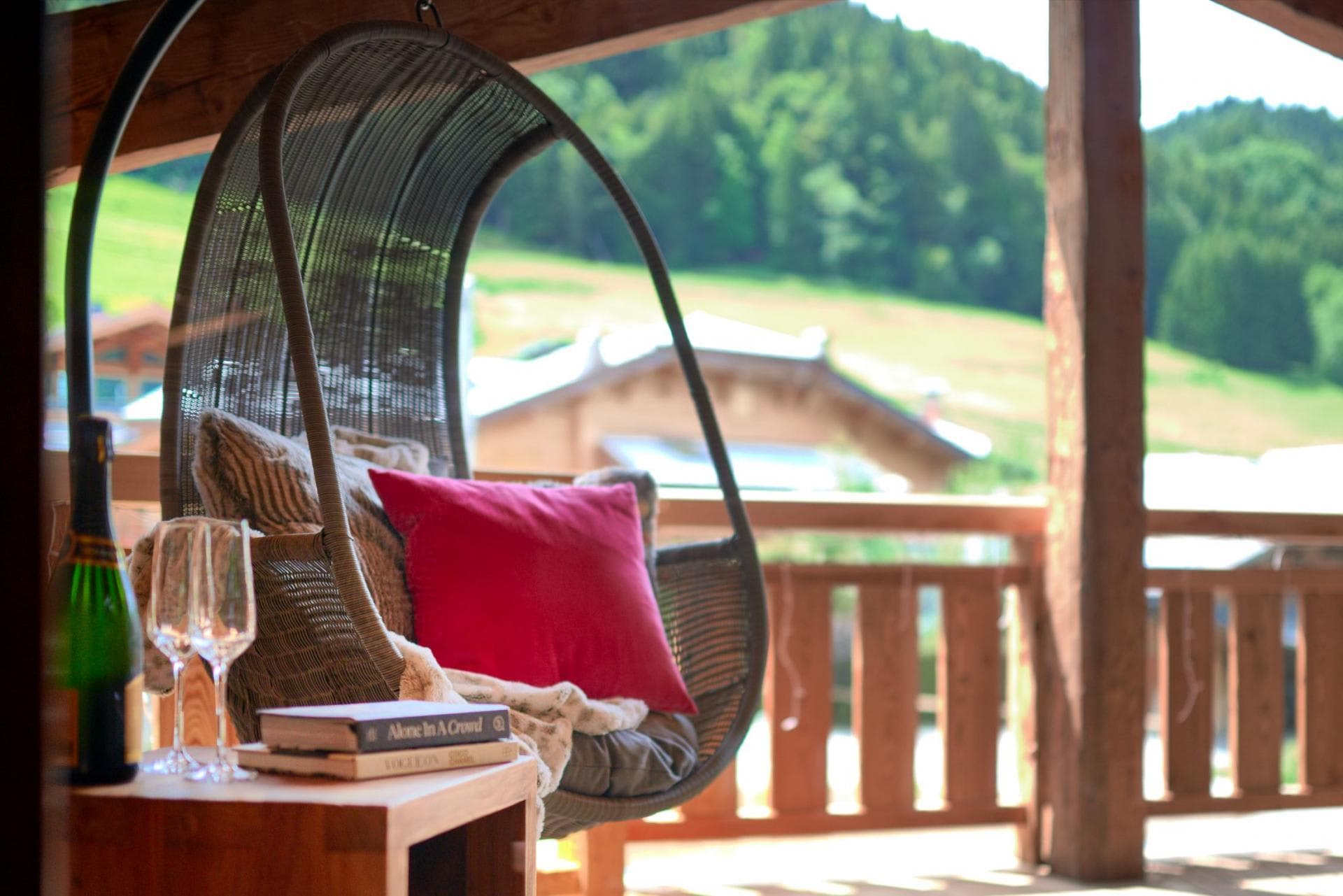 Private balcony with hanging egg chair and mountain views