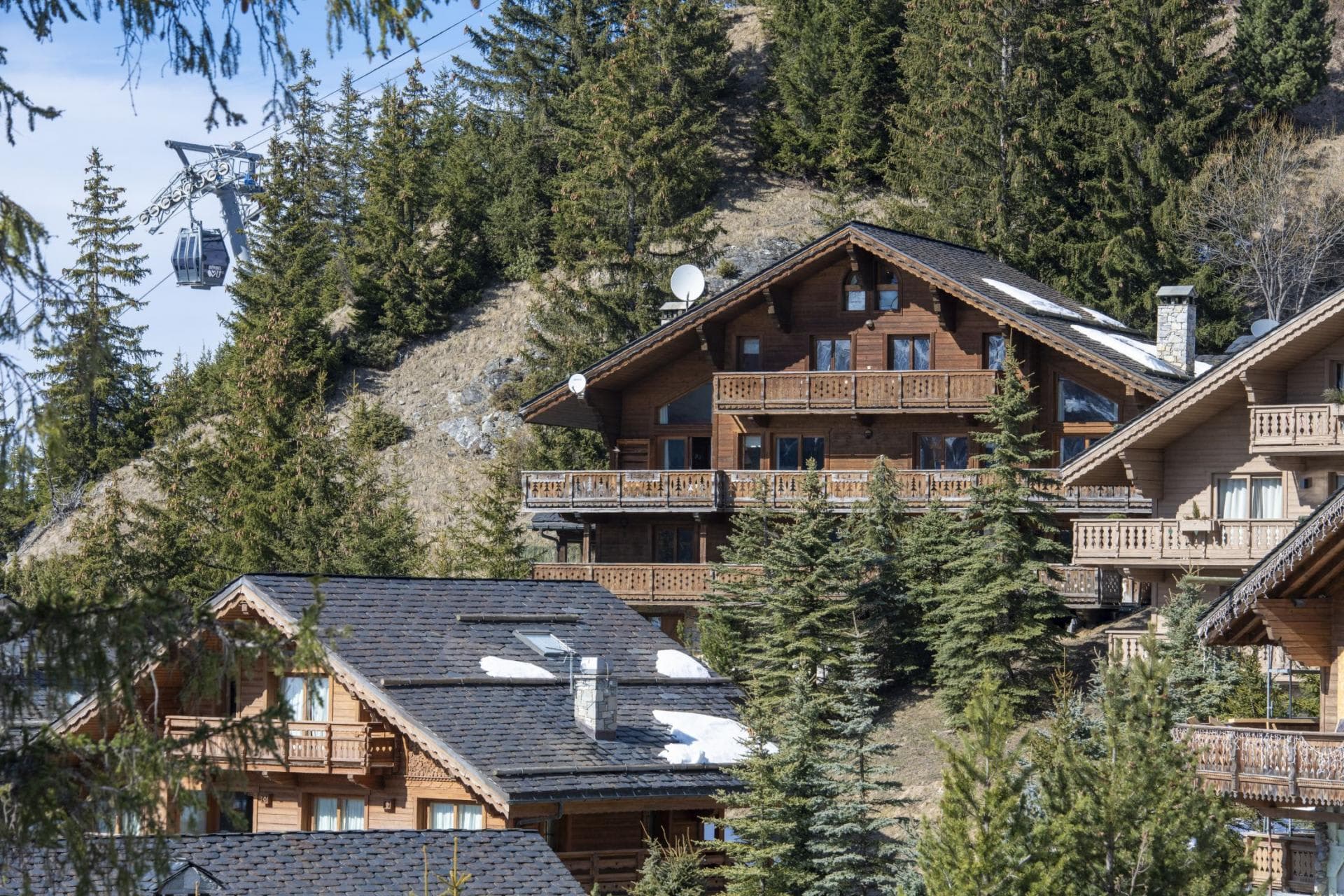 Mountain chalet with tiered balconies and view of nearby gondola