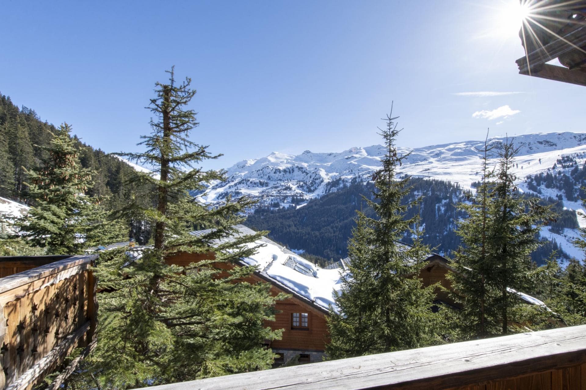 Balcony overlooking snow-capped mountains and neighboring chalets