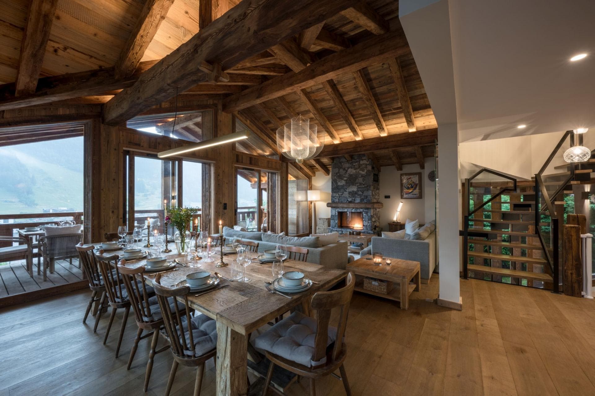 Open-plan living area with dining for 10, stone fireplace, and mountain views