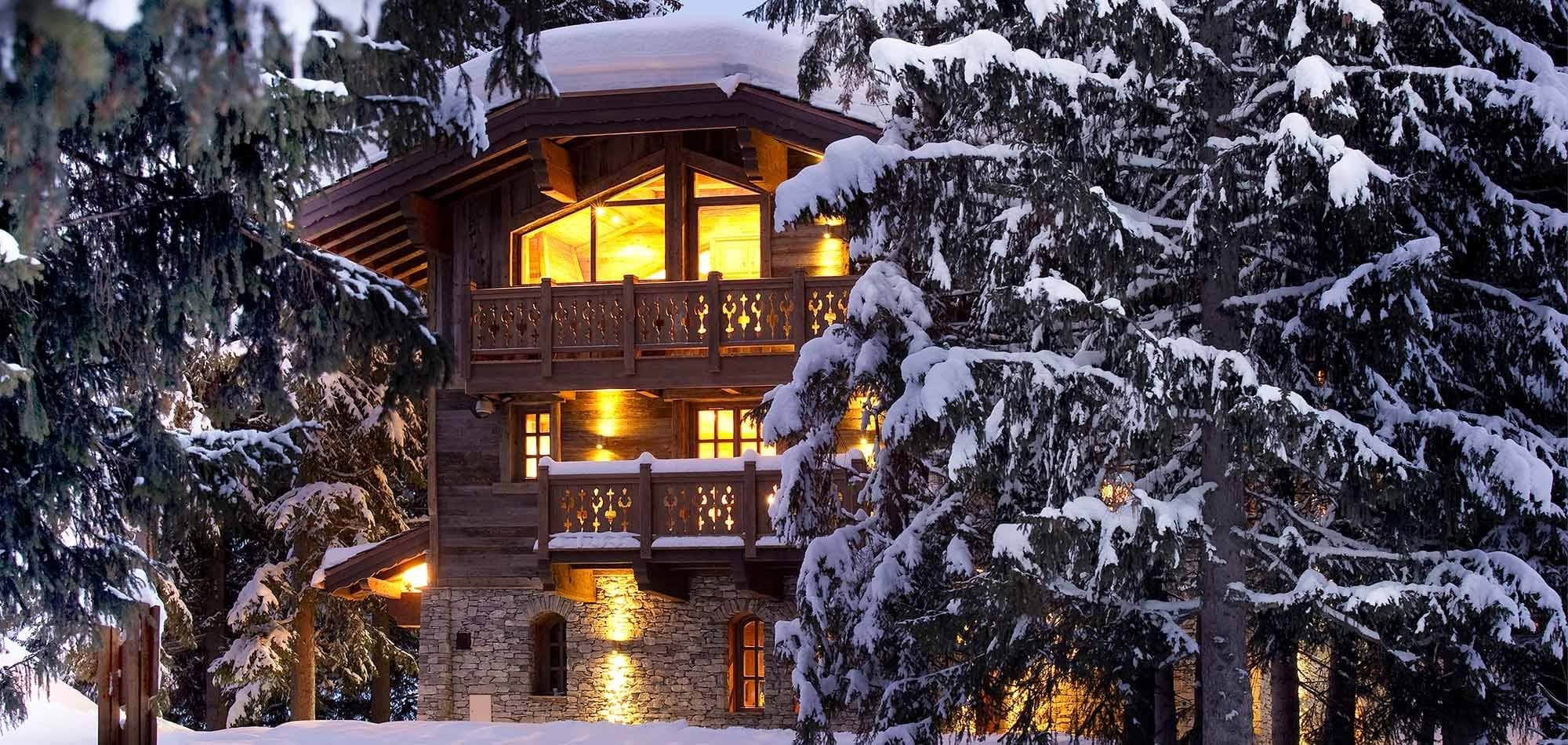 Ski-in chalet exterior featuring dual balconies and stone-clad lower level