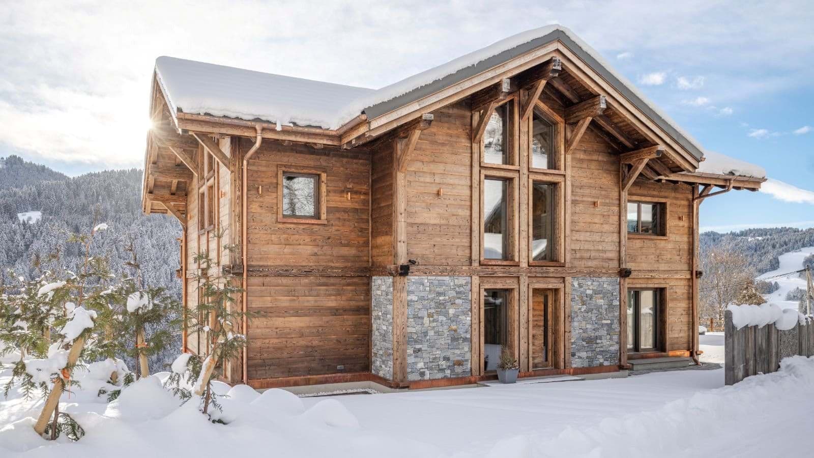 Ski-in chalet exterior with timber framing and floor-to-ceiling windows