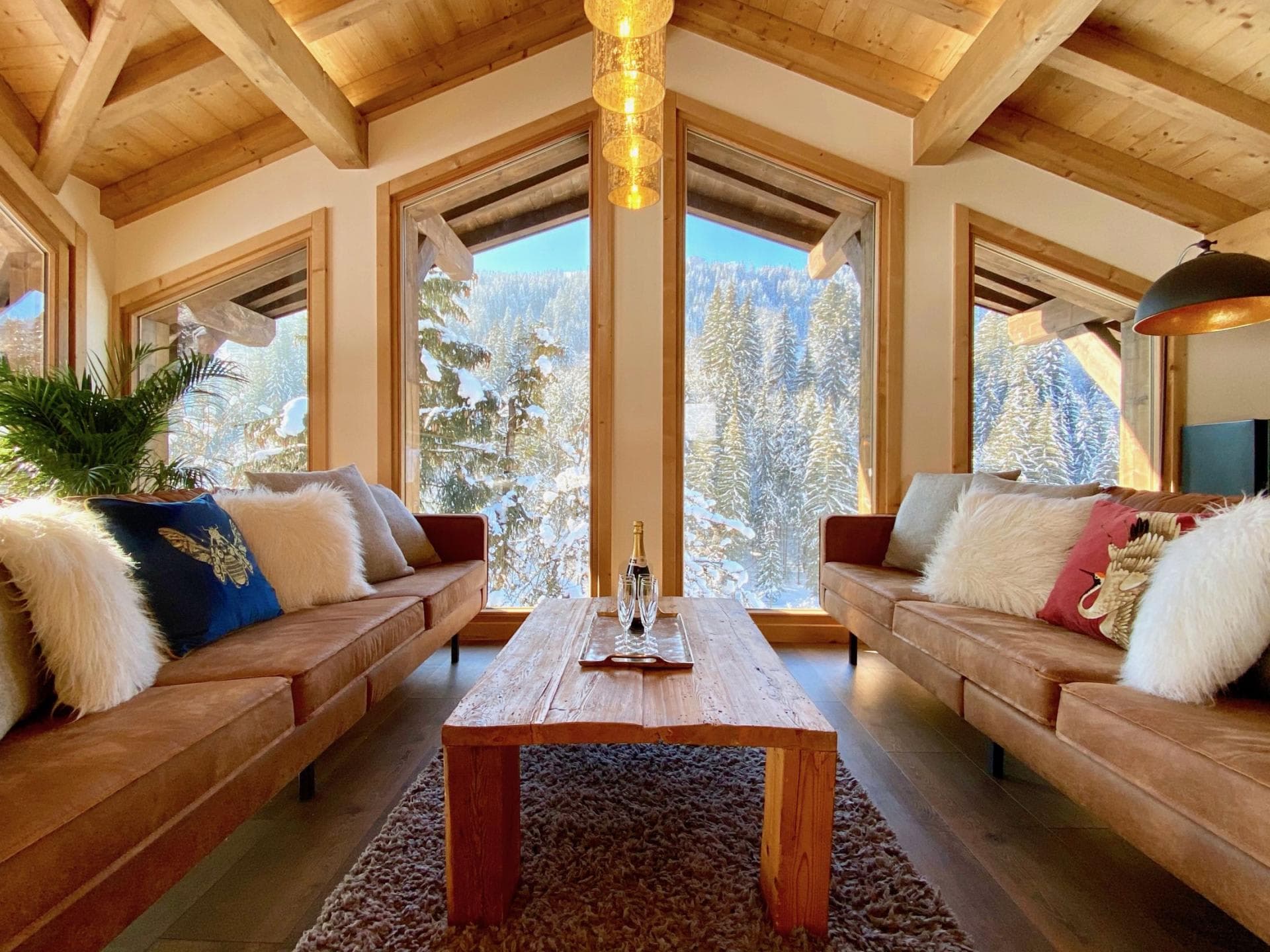 Living area with vaulted timber ceilings and forest views
