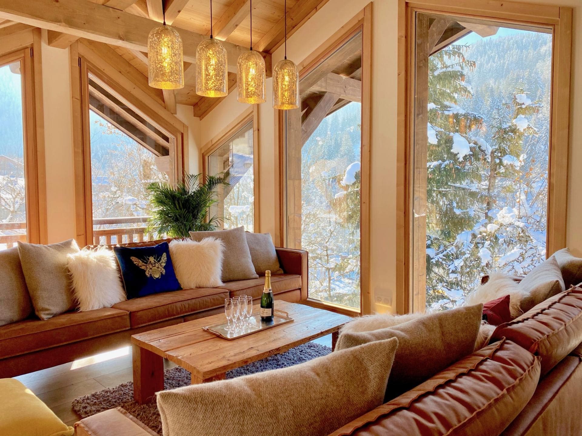 Living area with floor-to-ceiling windows and snowy forest views