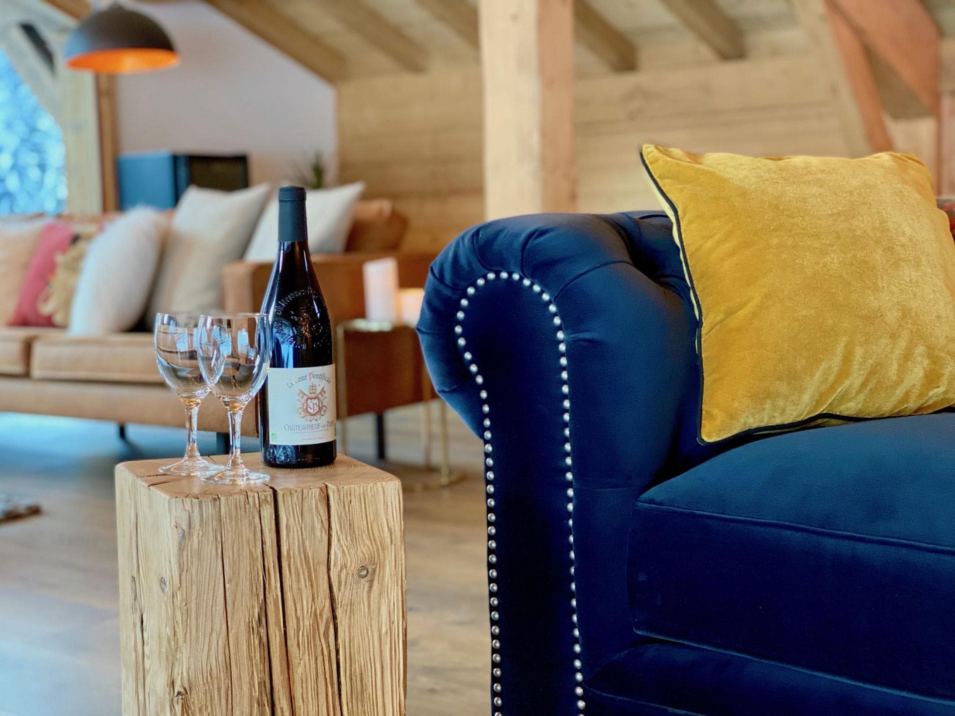 Living area with tufted velvet seating and rustic timber side table