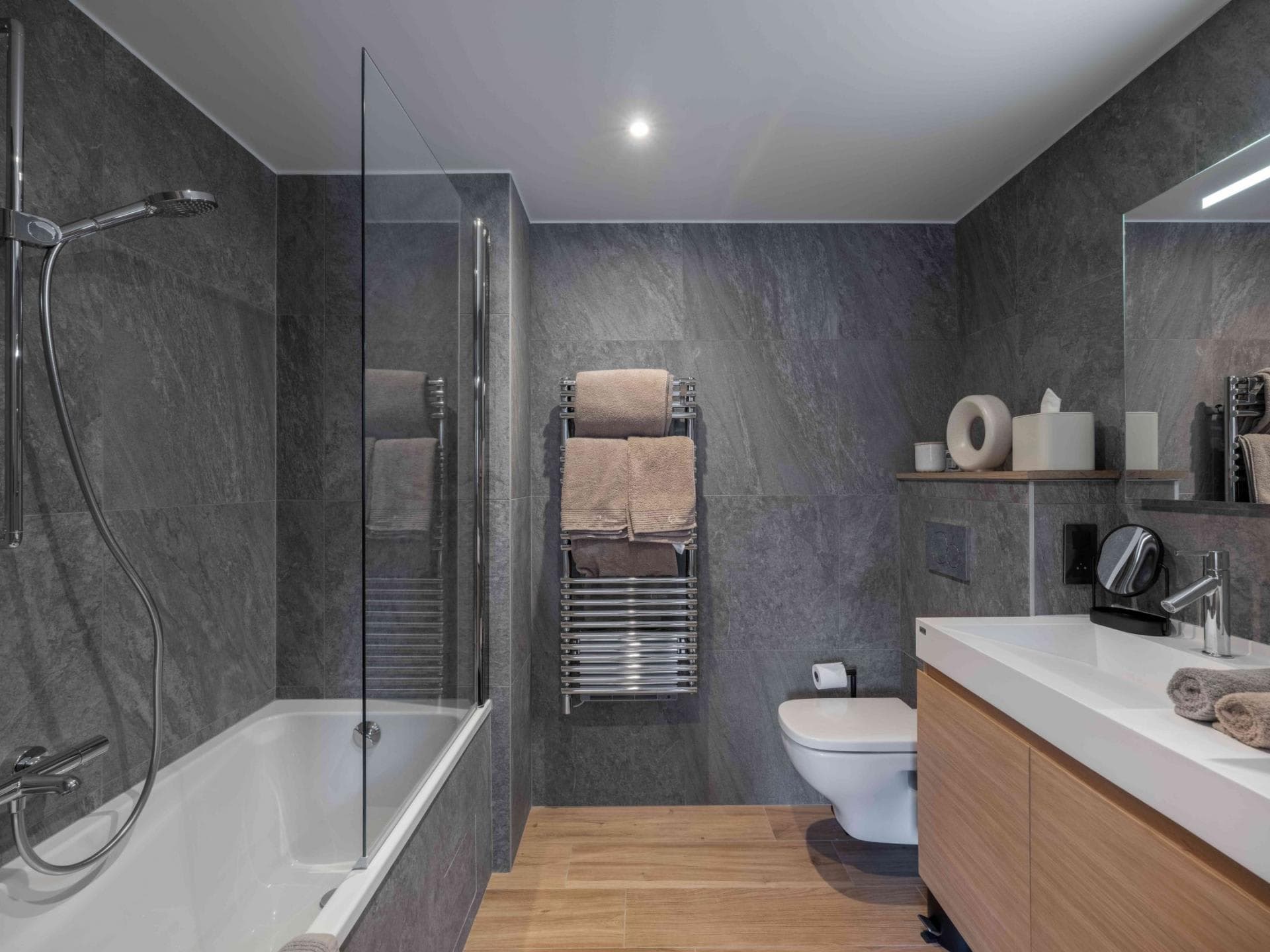 Bathroom with heated towel rail and soaking tub with glass partition