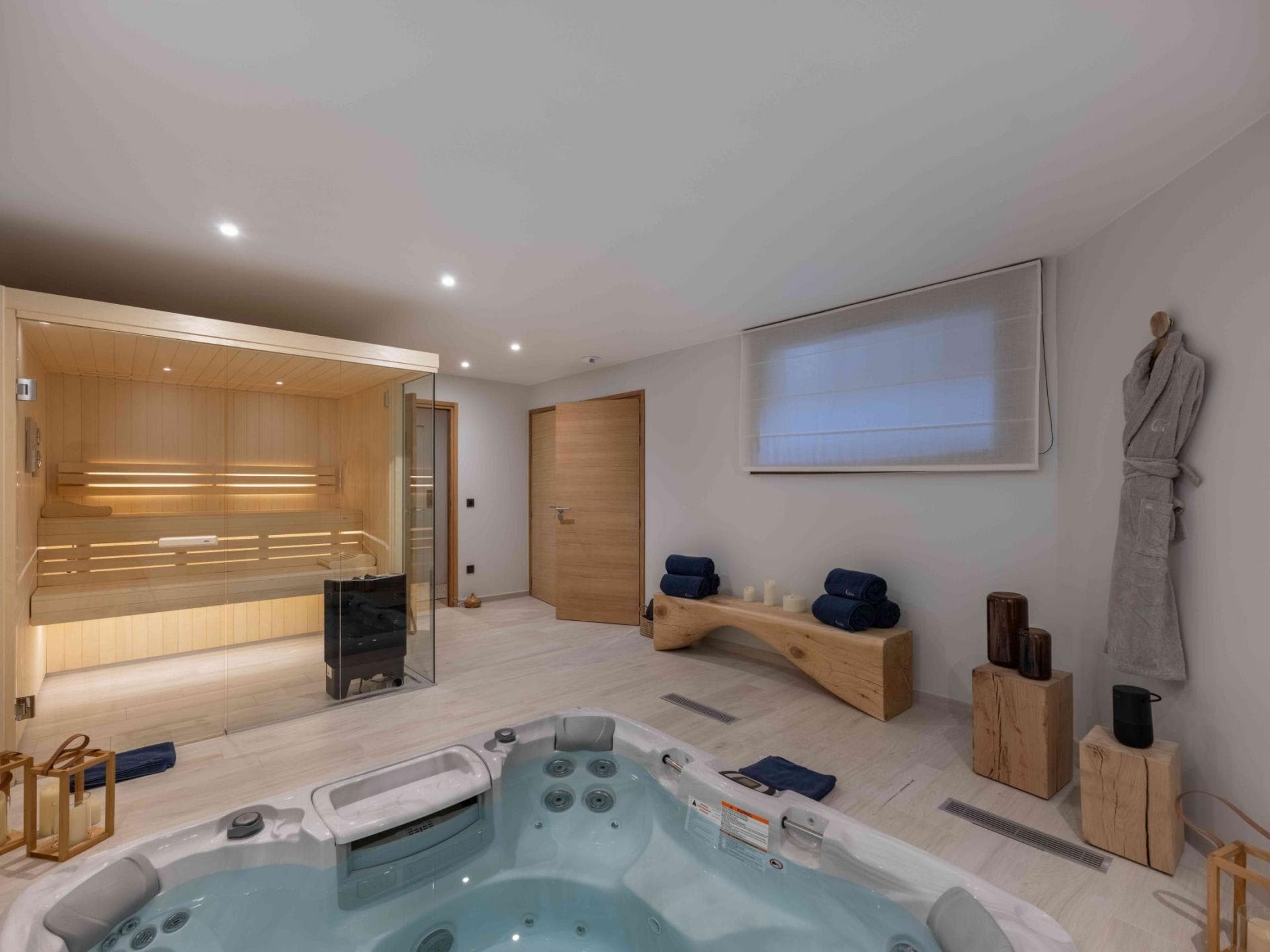 Indoor spa room with hot tub and private glass-walled sauna