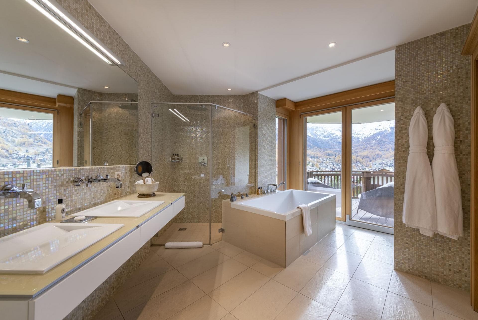 Bathroom with dual vanity, soaking tub, walk-in shower, and mountain views