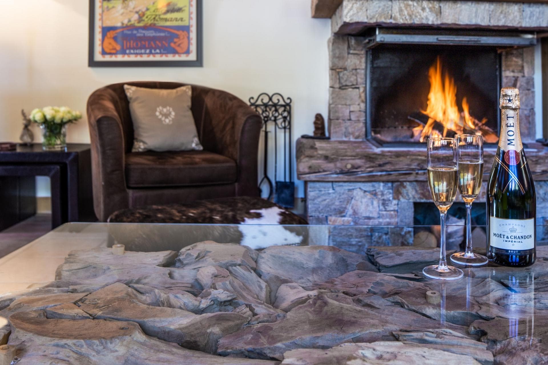 Living area with wood-burning stone fireplace and swivel armchair