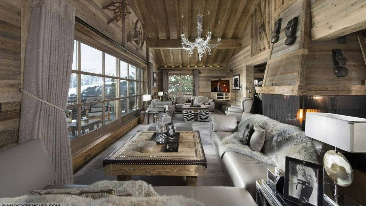 Living area with wood-burning fireplace and floor-to-ceiling mountain views
