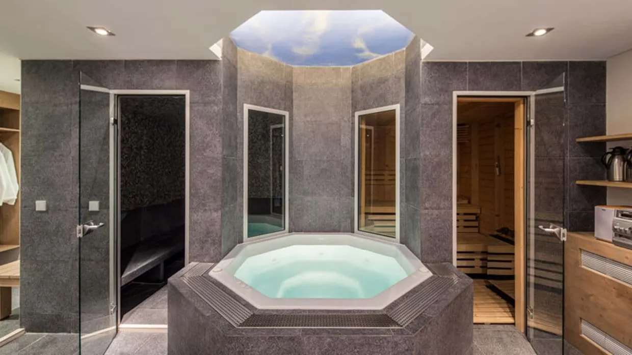 Spa area with jetted hot tub, steam room, and wood-paneled sauna