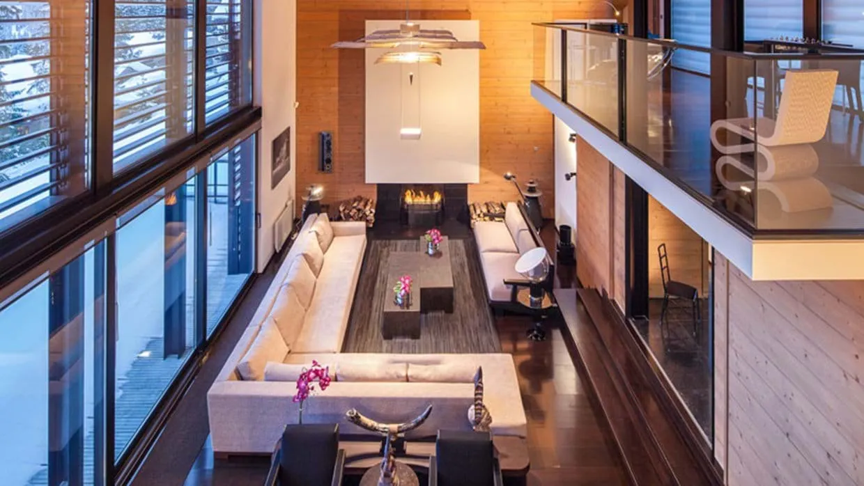 Double-height living room with wood-burning fireplace and mezzanine balcony