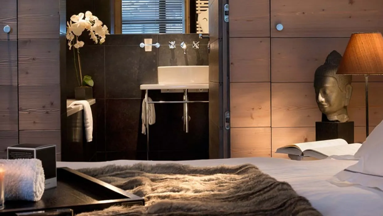 Primary bedroom with ensuite bathroom and timber paneled walls