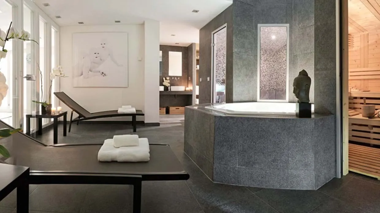 Private spa area with jetted tub, wooden sauna, and lounge seating