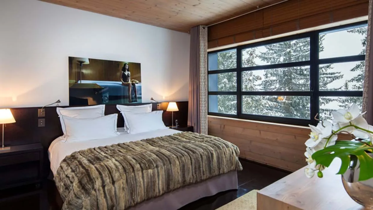 Guest bedroom with king bed and snow-covered forest views