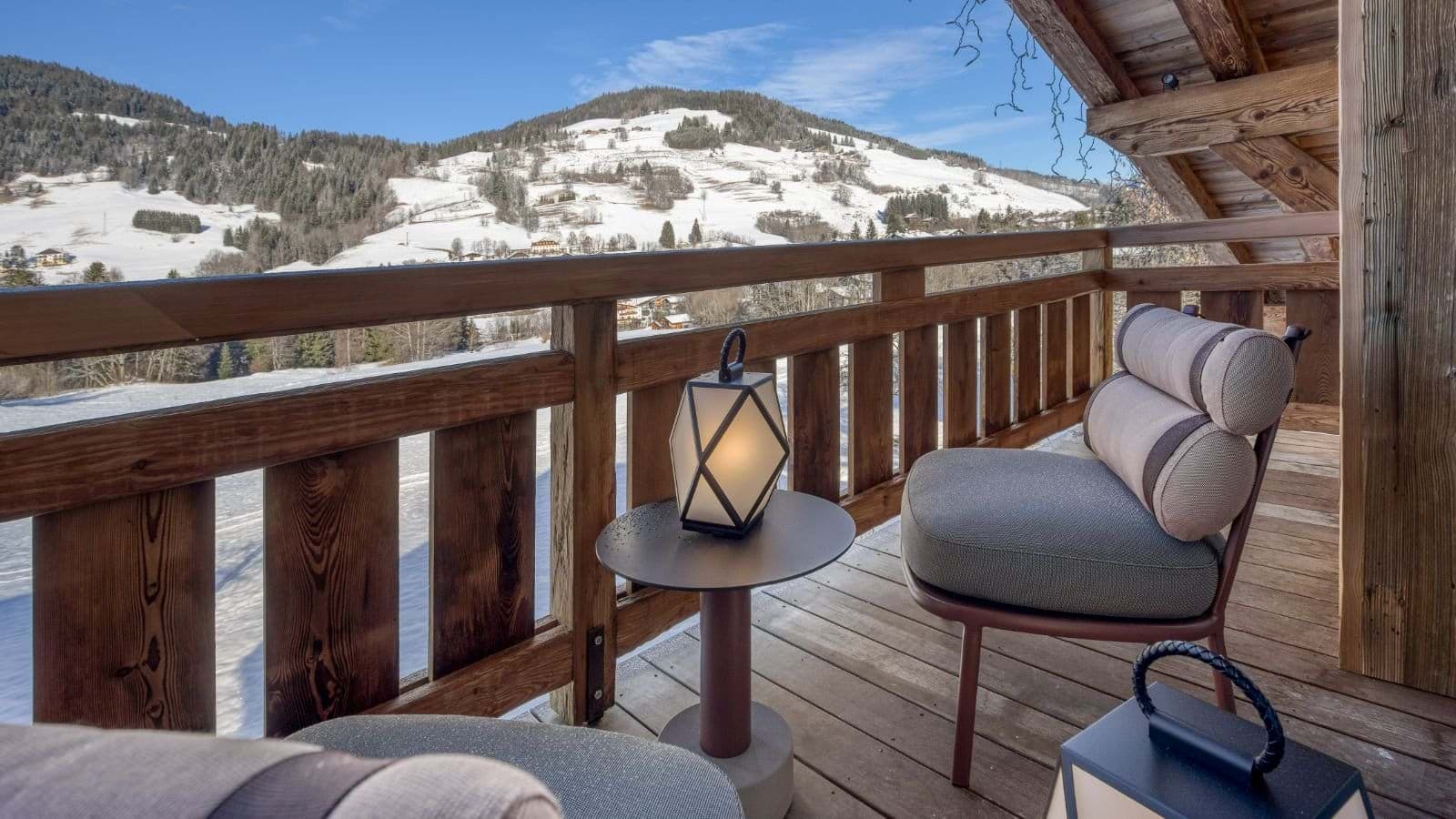 Private balcony with lounge seating and panoramic alpine valley views