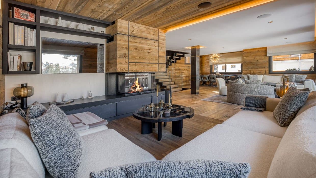 Open-plan living area with three-sided fireplace and reclaimed wood finishes