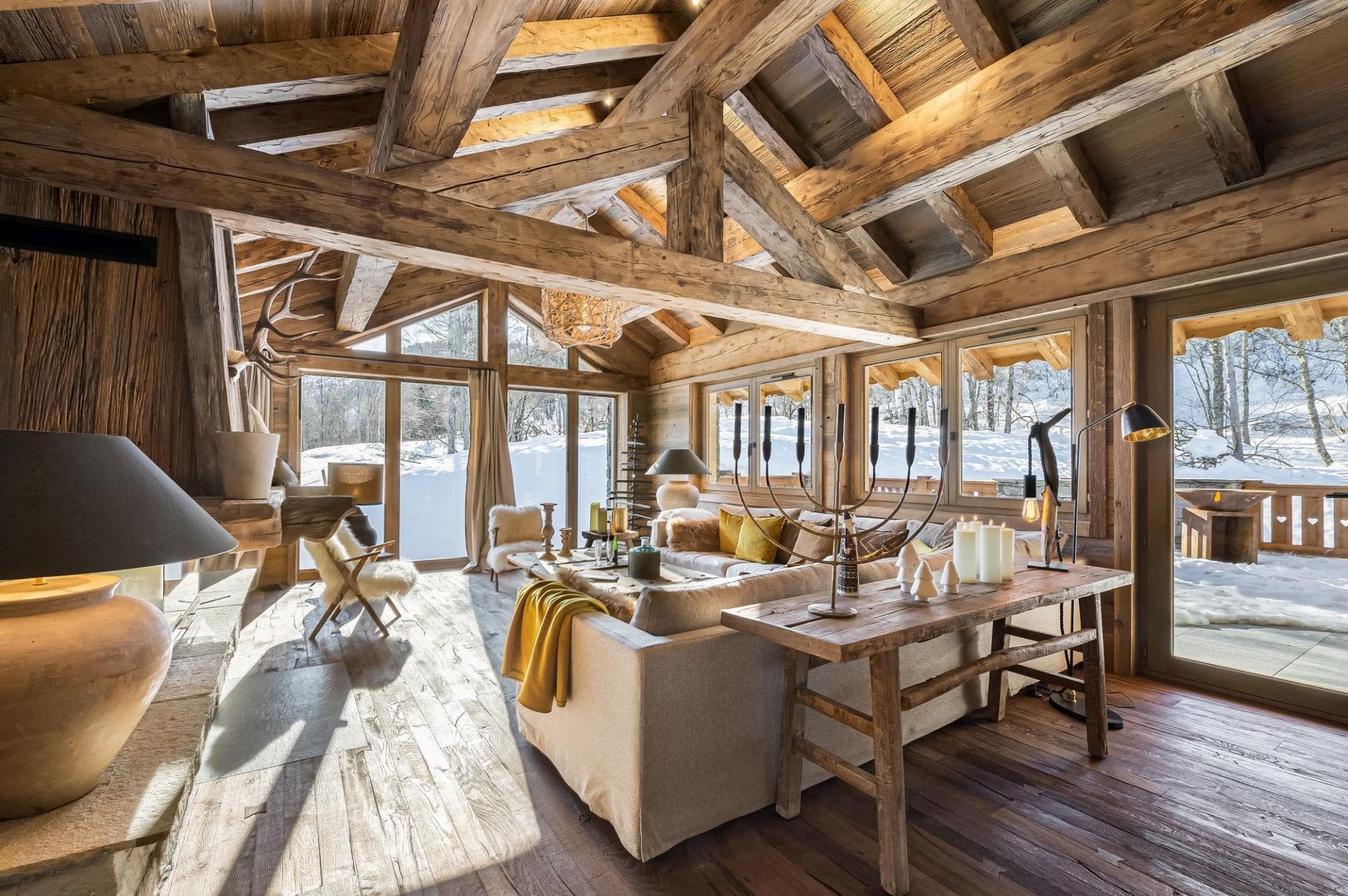 Living area with vaulted timber ceilings and floor-to-ceiling snow views