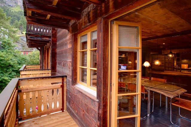 Private balcony with forest views and glass-door access to dining area
