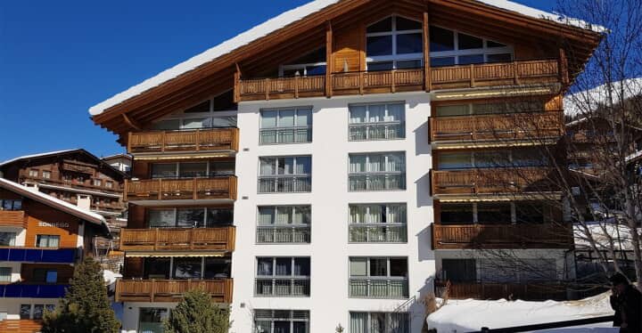 Chalet exterior with private balconies and snow-covered terrain