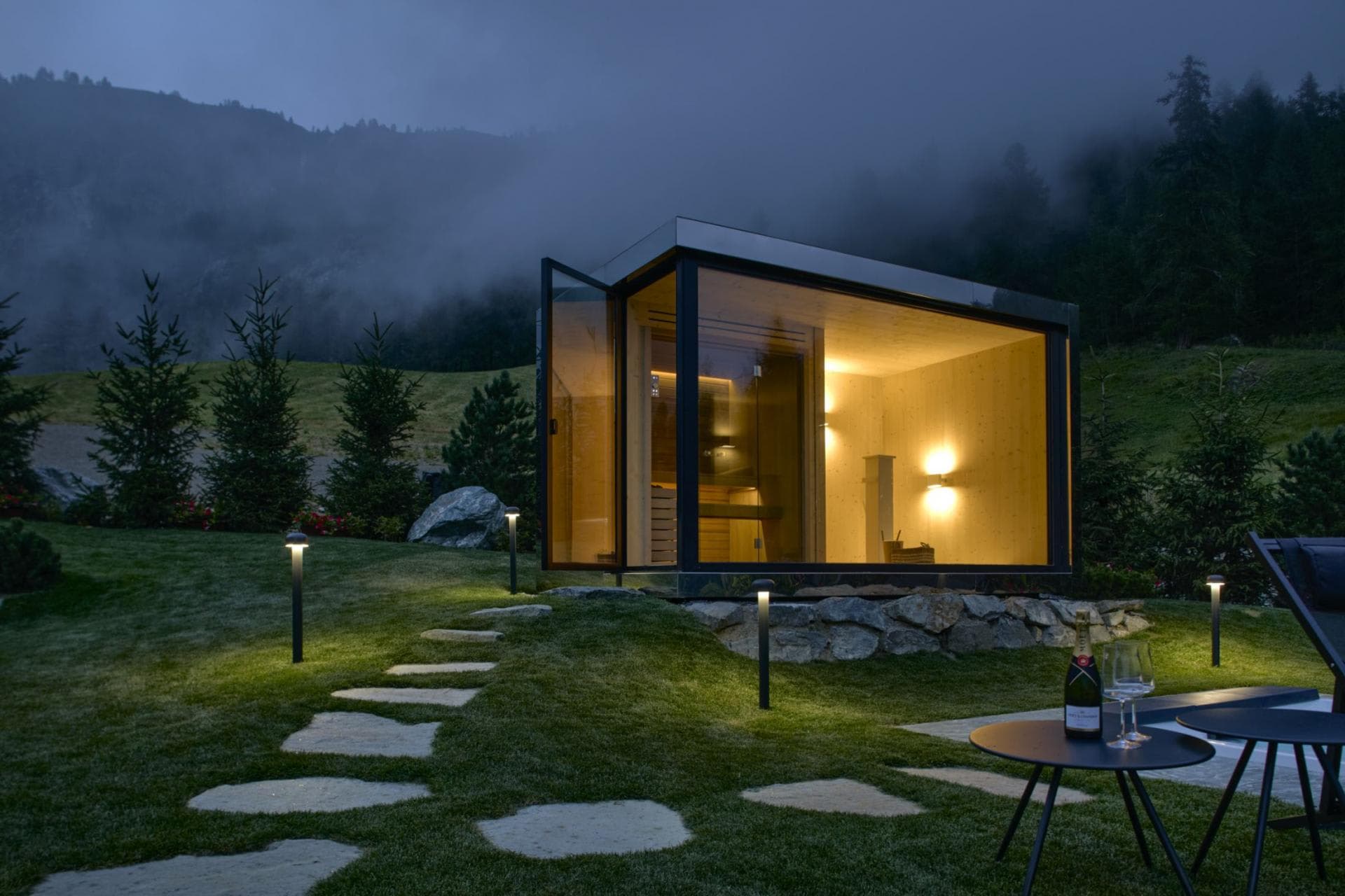 Detached glass-front sauna with stone path and mountain views