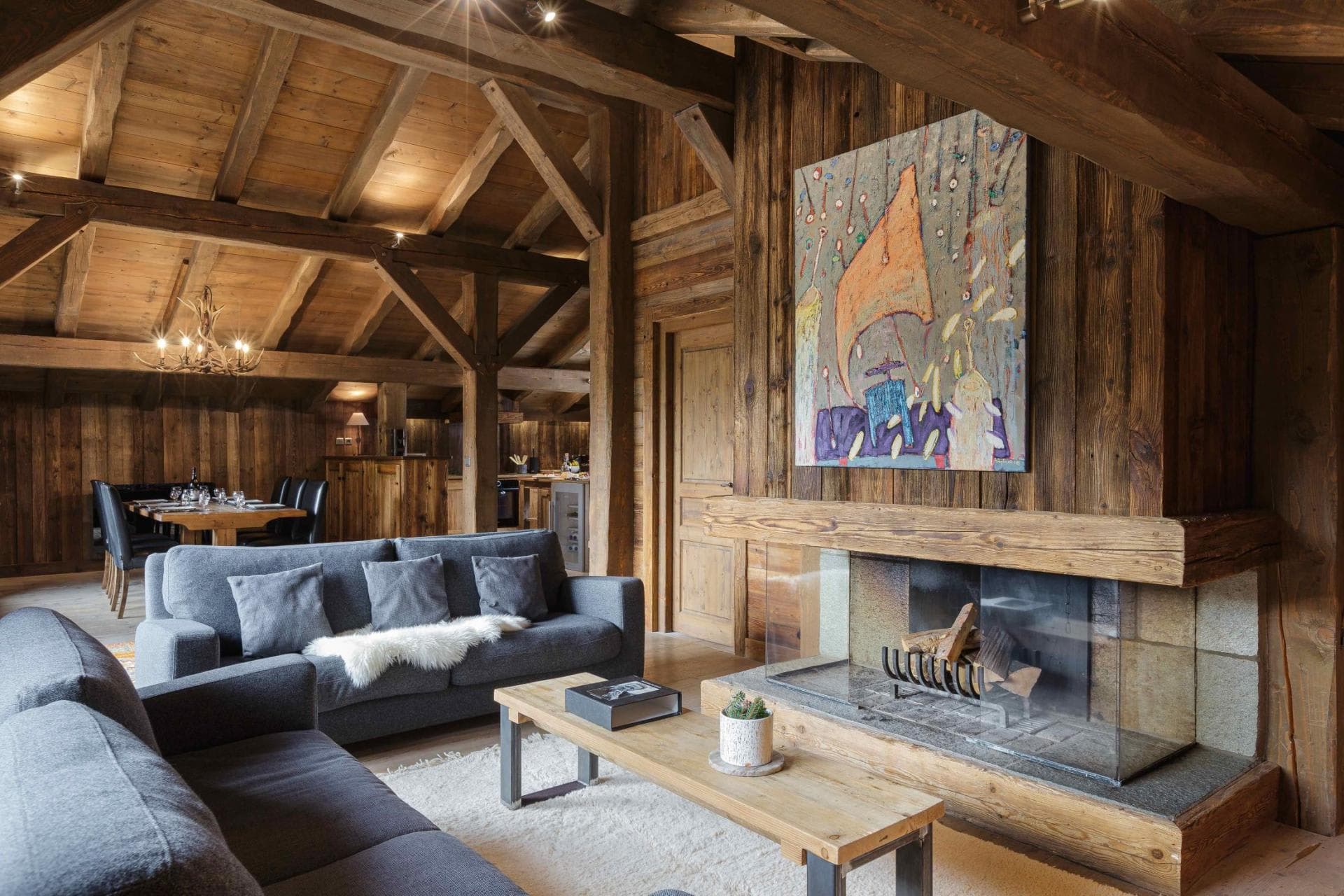 Open-plan living area with wood-burning fireplace and exposed timber beams