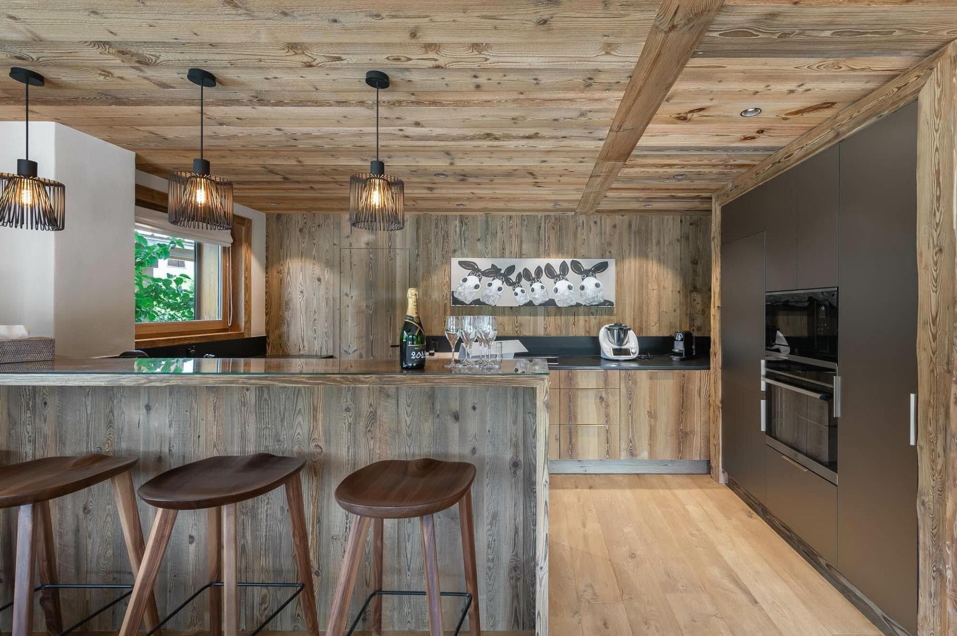 Kitchen with reclaimed wood finishes, island seating, and integrated wall oven