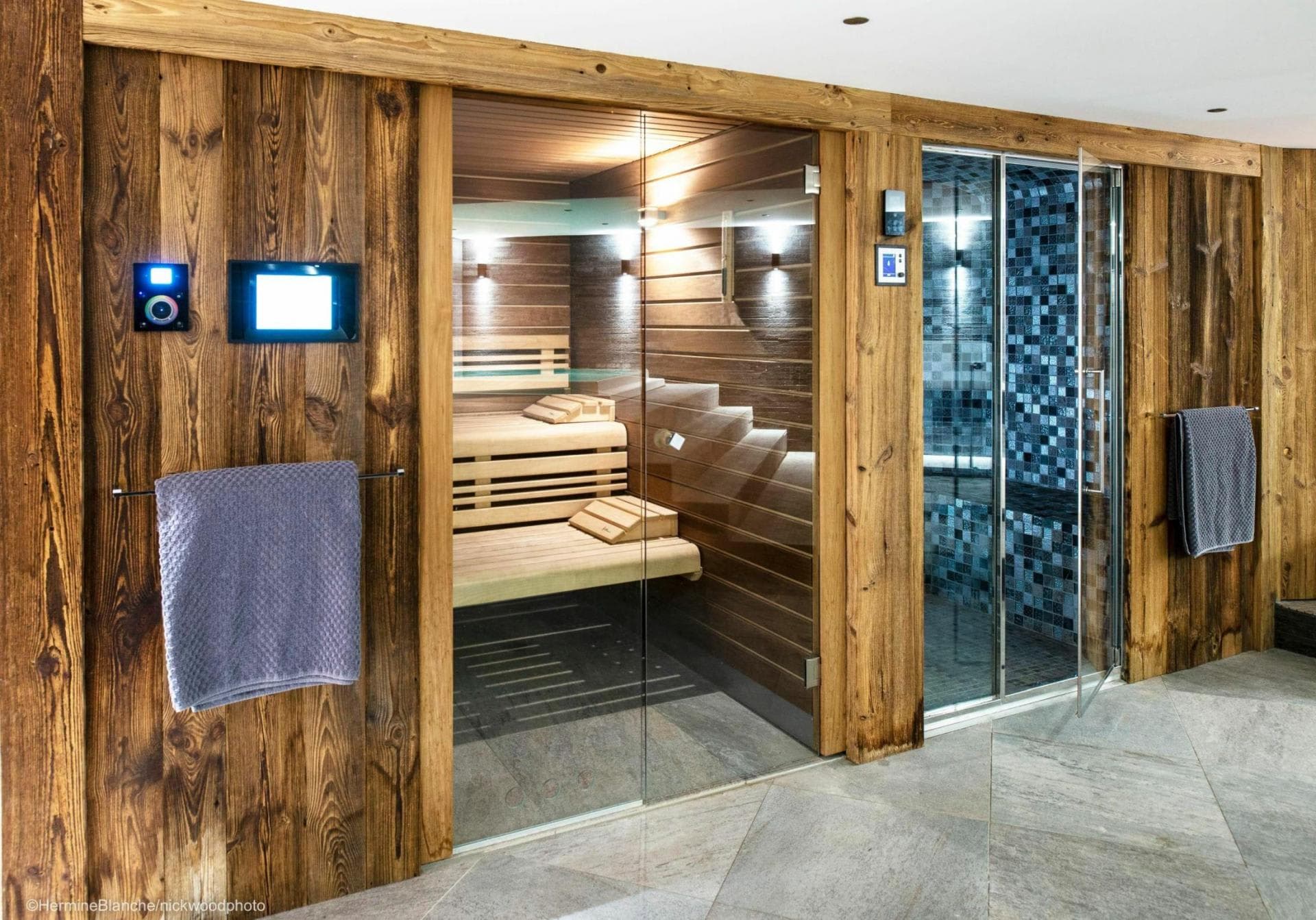 Private spa area featuring wood-paneled sauna and adjacent steam room