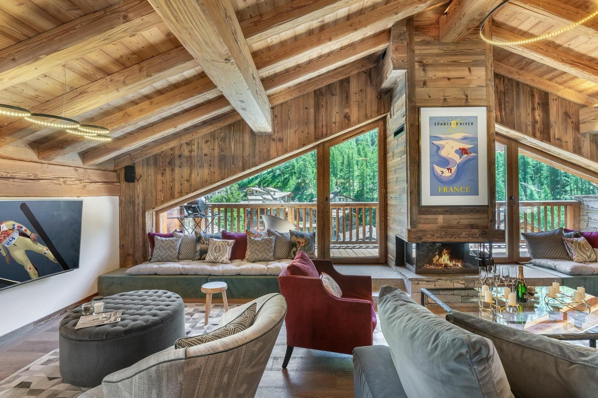 Living area with wood-burning fireplace and balcony access to forest views