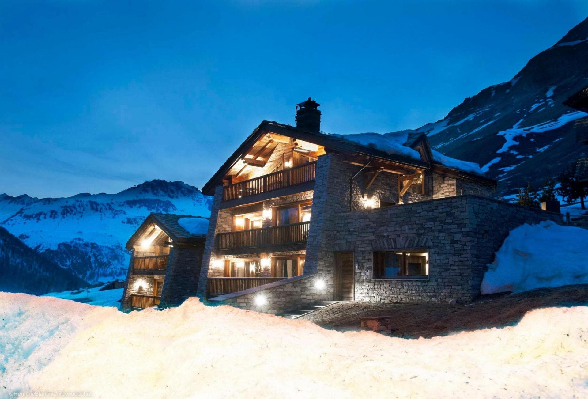 Stone-clad chalet with multiple balconies and direct mountain access