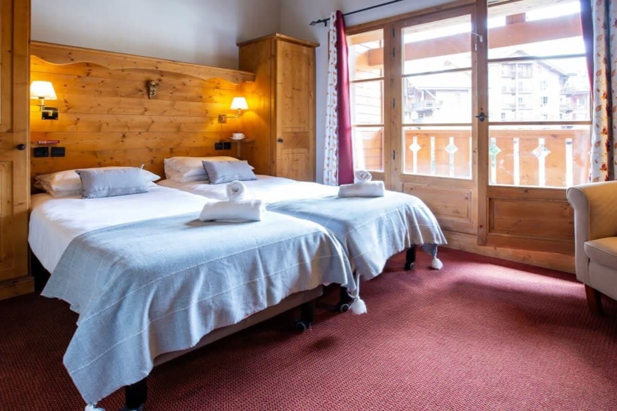 Guest bedroom with two twin beds and private balcony access