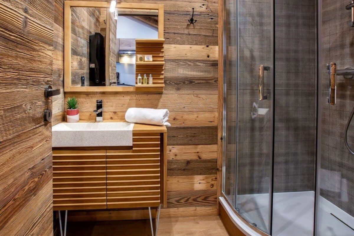 Bathroom with walk-in glass shower and reclaimed wood paneling