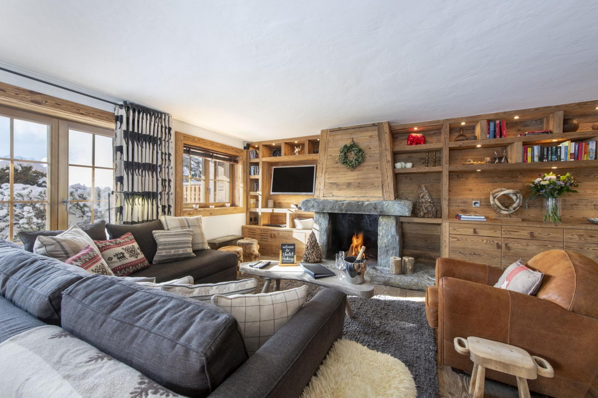 Living area with wood-burning stone fireplace and integrated library shelving