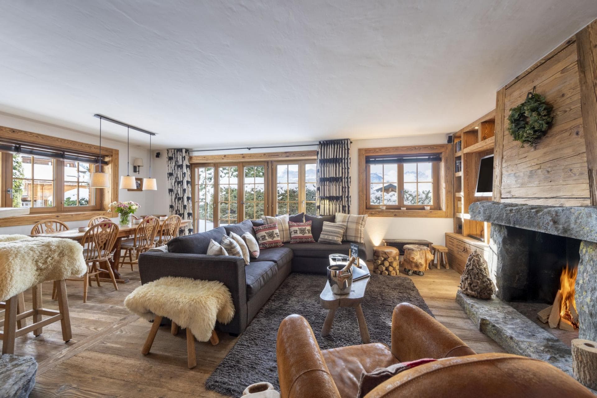 Open living area with wood-burning stone fireplace and balcony access