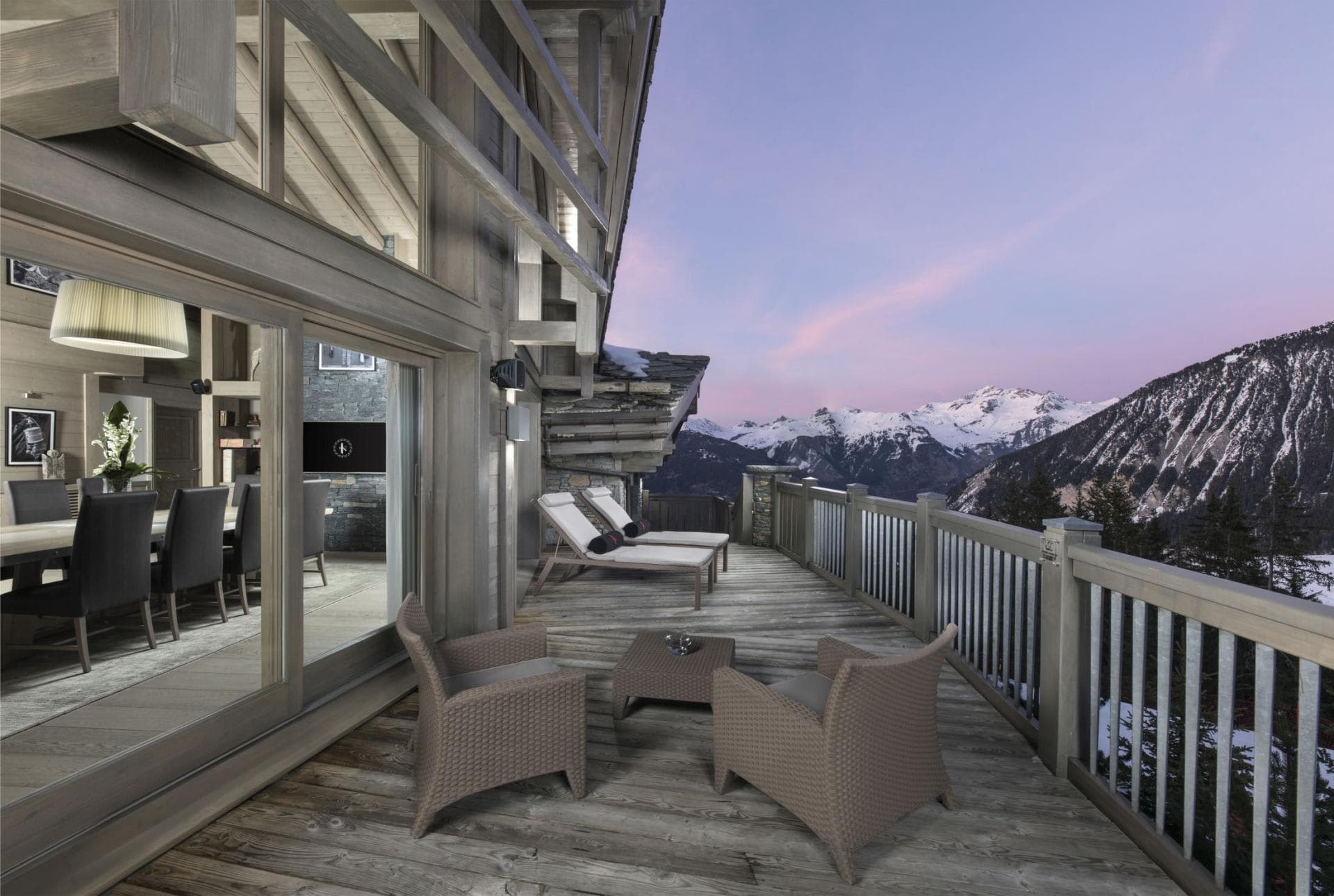 Deck with mountain views; two lounge chairs and white railing overlook snow-capped peaks